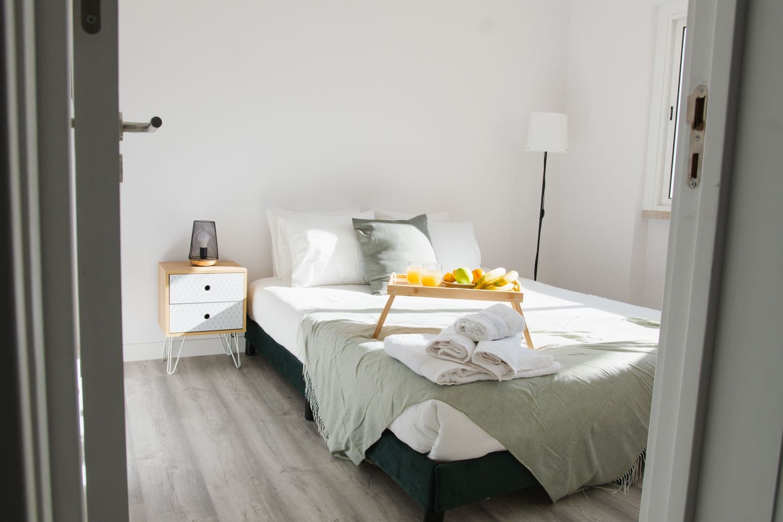 A made bed with a breakfast tray