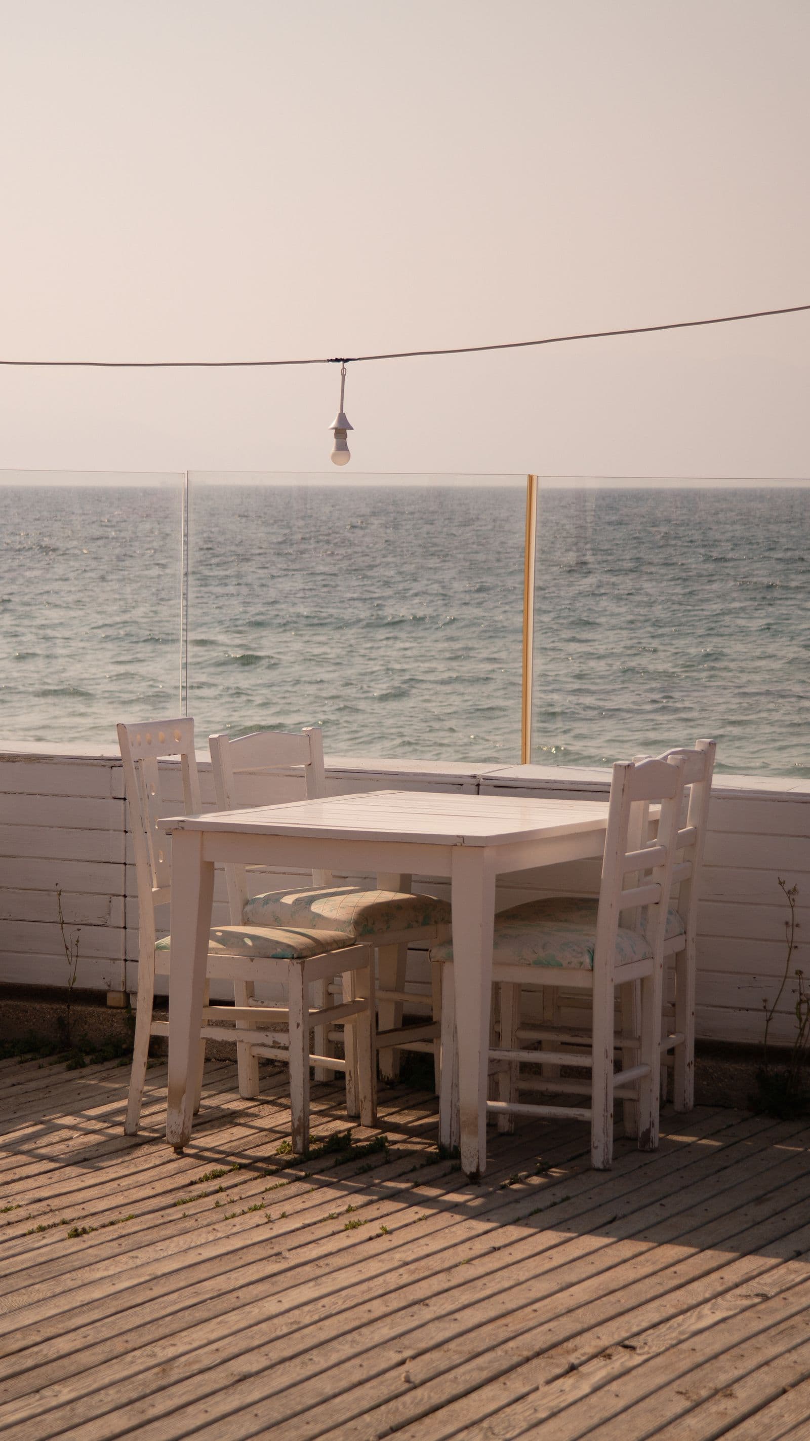 An outdoor table and chairs set by the water